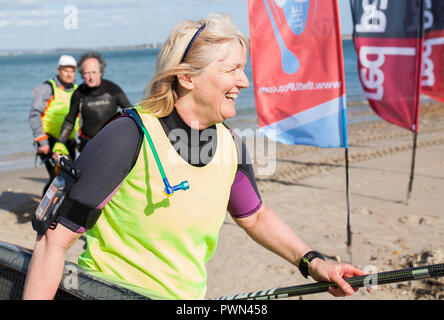 Medioevo Donna che cammina con paddle board su linea di finitura Foto Stock