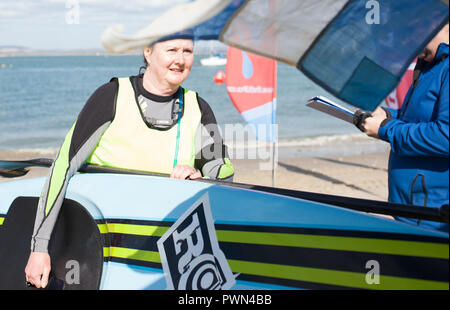 Medioevo Donna che cammina con paddle board su linea di finitura Foto Stock