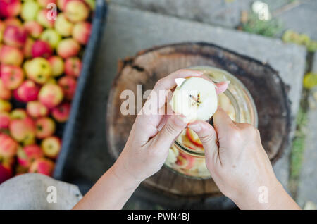 Realizzazione di aceto di mele - scena dal di sopra - mano sbucciare le mele Foto Stock