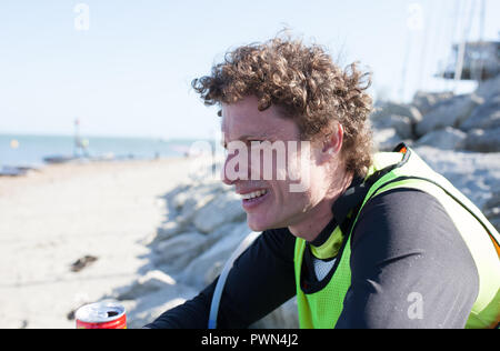 L'uomo esaurito dopo aver preso parte a una scheda di paddle race Foto Stock