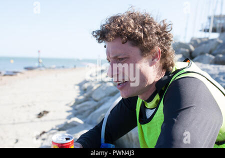 L'uomo esaurito dopo aver preso parte a una scheda di paddle race Foto Stock