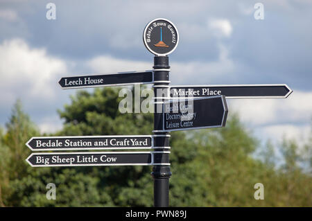 Direzione pedonale segno rivolto alle attrazioni intorno a Bedale in North Yorkshire Foto Stock