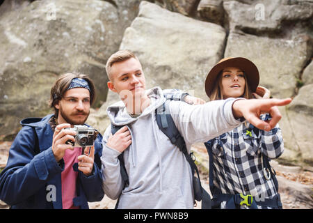 Bella bionda viaggiatore mostrando grande posto al suo amico, il suo barbuto amico pronto a scattare una foto della vista, ragazza guardando e ammirando, concetto di viaggio Foto Stock