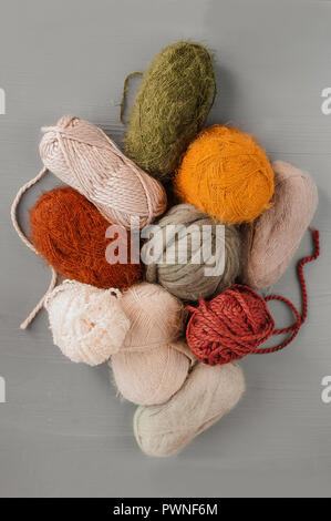 Varietà di filati per maglieria su sfondo grigio. Vista superiore Foto Stock