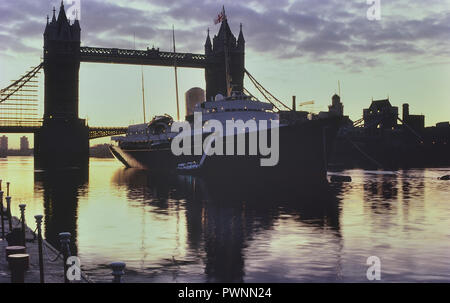 HMY Britannia Ormeggiato accanto il Tower Bridge di Londra, Inghilterra, Regno Unito. Circa ottanta Foto Stock