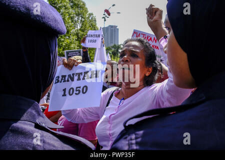 Kuala Lumpur, Malesia. Xvii oct, 2018. Una donna vede gridando slogan nella parte anteriore di un poliziotto per mostrare alcuni solidarietà a #Bantah1050 rally per protestare contro il salario minimo del lavoratore malese a campo Merbok.centinaia di Malaysian studenti e lavoratori hanno marciato insieme per sostenere il #Bantah1050 rally per protestare contro il lavoratore malese salario minimo e la domanda per aumentare il salario minimo a RM 1800. Il nuovo governo della Malesia ha annunciato il salario minimo sollevare fino a RM 1050 e saranno effettivamente il 1 Gennaio 2019 compresi Sabah e Sarawak. #Bantah1050 rally aveva b Foto Stock