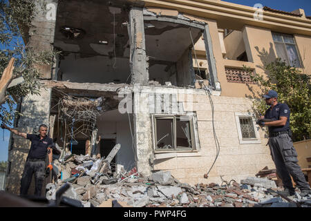 Beer Sheva, città israeliana di Beer Sheva. Xvii oct, 2018. La polizia israeliana esaminare una casa che ha sofferto un colpo diretto da un razzo secondo come riferito ha sparato da gruppi militanti dalla striscia di Gaza, nella parte meridionale della città israeliana di Beer Sheva, il 17 ottobre, 2018. Israele il portavoce militare ha detto mercoledì che l'esercito vede la cottura di due razzi su Israele in precedenza al mattino "un grave incidente." Credito: JINI/Xinhua/Alamy Live News Foto Stock