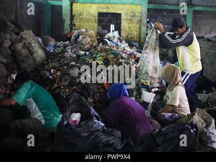 Bogor, West Java, Indonesia. Xviii oct, 2018. Lavoratori sorta rifiuti raccolti presso le famiglie e i mercati tradizionali. I rifiuti banca gestisce su base comunitaria rifiuti dal trattamento dei rifiuti come una risorsa che è ecologico, educative e valori economici ??in modo che diventi un progetto pilota per la 3R gestione dei rifiuti Credito: Adriana Adinandra SOPA/images/ZUMA filo/Alamy Live News Foto Stock