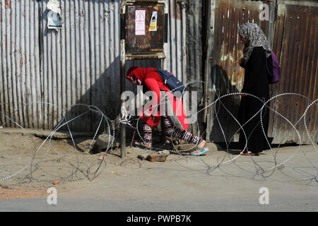 Srinagar Kashmir. Xviii Ott 2018. Le ragazze del Kashmir cercando di attraversare il filo spinato insieme da forze indiane , durante il coprifuoco simili restrizioni in parti della valle .Il Giunto resistenza Leadership (JRL), un conglomerato separatista guidato da Syed Ali Geelani, Mirwaiz Umer Farooq e Muhammad Yasin Malik, chiamato l'arresto contro l'uccisione di Lashkar-e-Taiba (LET) commander,Mehrajudd in Bangroo, suo associare Faiz Ahmad Waza e Rayees Ahmad in uno scontro a fuoco il mercoledì a Srinagar's Fateh Kadal area.©Sofi Suhail/Alamy Live News Foto Stock