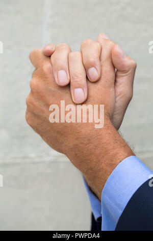Close-up sulle mani di un imprenditore che "strofina le mani". Foto Stock