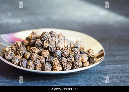 Spezie su un cucchiaio di legno con un background di ardesia. Ottobre 2018 Foto Stock