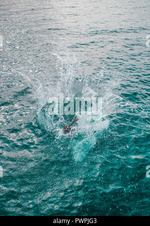 Splash come persona salti in acque turchesi del Mar dei Caraibi Foto Stock