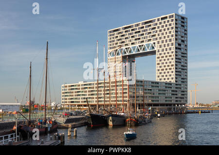 AMSTERDAM, Paesi Bassi - 11 October, 2018: Il moderno edificio di appartamenti Pontsteiger da Arons & Gelauff, con navi storiche inserito nella parte anteriore. Foto Stock