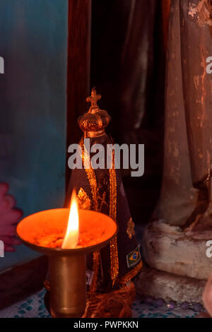 Immagine della Madonna apparsa su un altare illuminato da una candela durante il culto religioso all'interno del Brasile Foto Stock