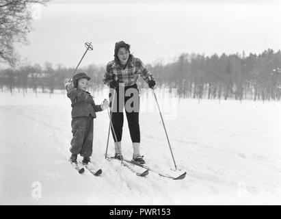 In inverno i 1940s. L'attrice Märta Torén, 1925-1957, in un giorno di inverno Sciare con suo figlio. La Svezia 1940s. Foto Kristoffersson ref 198A-2 Foto Stock