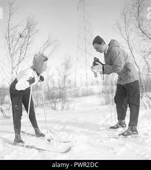 In inverno i 1940s. Attore Nils Kihlberg, 1915-1965 è raffigurato qui con la moglie Ann-Britt. Egli è di scattare le foto di lei per la loro vacanza invernale. Essi sono entrambi di indossare abbigliamento invernale e sci. La fotocamera è una Rolleiflex dalla società tedesca Rollei. La Svezia 1940s. Foto Kristoffersson Ref D73-4 Foto Stock