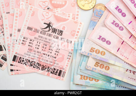Taipei, Taiwan - 7 OTT 2018: primo piano della moneta di Taiwan e Taiwan biglietti della lotteria: Grande Lotto. Foto Stock