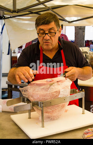 Un fornitore di prosciutto di taglio su un mercato nel sud della Francia Foto Stock