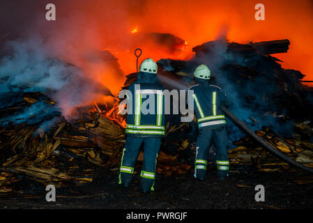 Fireman estinguere il fuoco Foto Stock