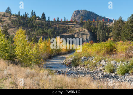 Trout Creek gigante e di testa della montagna con foglie di autunno sugli alberi vista da Kettle Valley Rail Trail Foto Stock