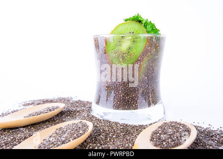 Bibita salutare in vetro con semi di Chia, kiwi e succo di limone su sfondo bianco Foto Stock