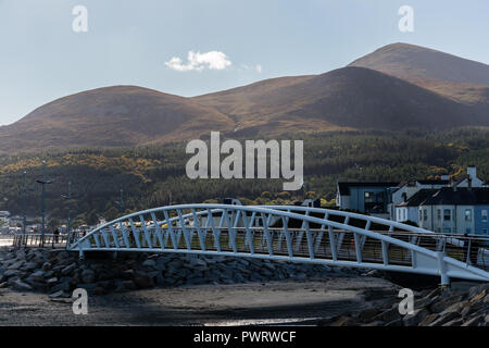 Passerella sul fiume Shimna collegando le passeggiate con vista di Mourne Mountains con Slieve Donard. Newcastle, County Down, N.Irlanda. Foto Stock