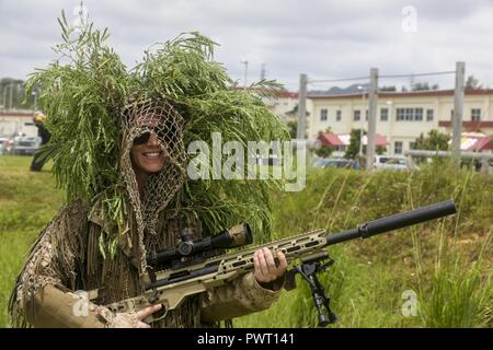 I coniugi di Marines con 3° Battaglione di ricognizione, terza divisione Marine, III Marine forza expeditionary, pongono in una Ghillie Suit mentre tiene un M40A5 Bolt-Action fucile da cecchino durante il Recon Rhonda evento a bordo di Camp Schwab, Okinawa, in Giappone, il 26 giugno 2017. Recon Rhonda è un gioco sulla tradizionale Jane Wayne day che le unità host, consentendo ai coniugi di partecipare a vari eventi che loro Marines eseguire quotidianamente. Foto Stock