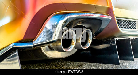 Doppio tubo di scarico di un arancio auto in una giornata di sole Foto Stock