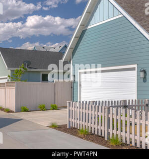 Garage e cortile di una casa contro un cielo nuvoloso Foto Stock