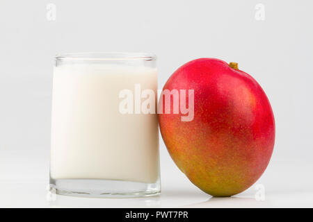Vetro con latte e frutta mango isolati su sfondo bianco Foto Stock
