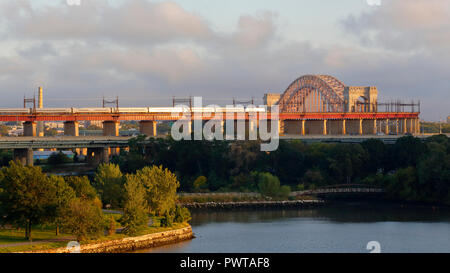 Un treno Amtrak in direzione sud si avvicina al ponte Hell Gate Bridge che collega Randalls Island con Queens a New York City Foto Stock