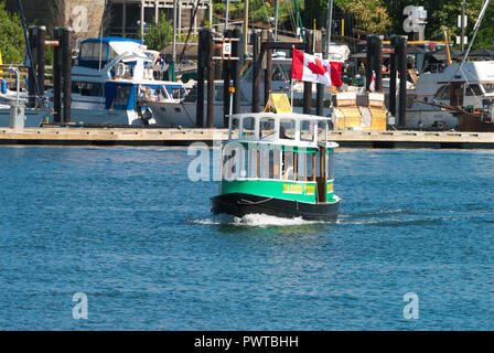 Un piccolo traghetto veleggia le acque del porto interno di Victoria, British Columbia, Canada Foto Stock