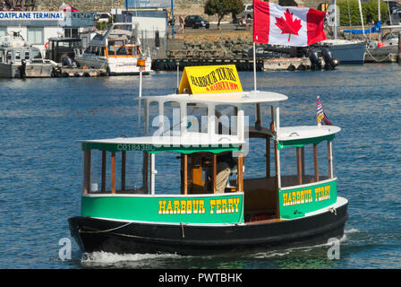 Un piccolo traghetto veleggia le acque del porto interno di Victoria, British Columbia, Canada Foto Stock