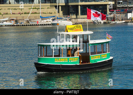 Un piccolo traghetto veleggia le acque del porto interno di Victoria, British Columbia, Canada Foto Stock