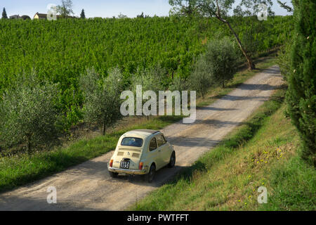 Vecchia fiat 500 di guida auto sulla via passato vigneti in Toscana,l'Italia,l'Europa Foto Stock