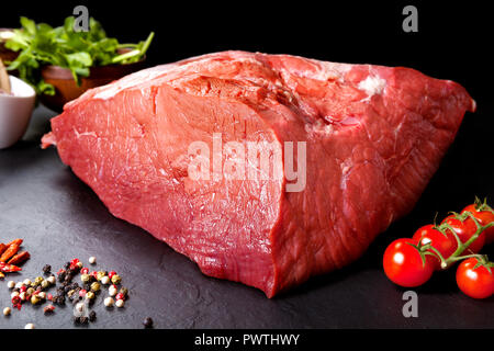 Fresco e carne cruda Butcher carne rossa pronto a cuocere sul barbecue. Nero lo sfondo della lavagna Foto Stock