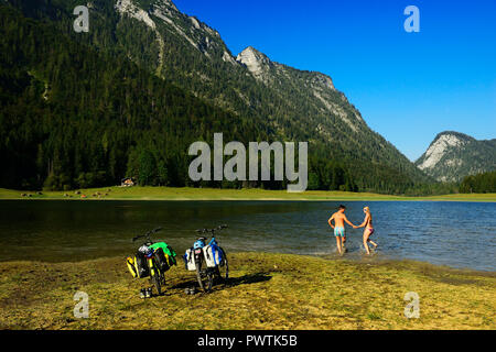 Due ciclisti sul ciclo di Mozart percorso, nuoto nel lago Mittersee, Ruhpolding, Chiemgau, Alta Baviera Foto Stock