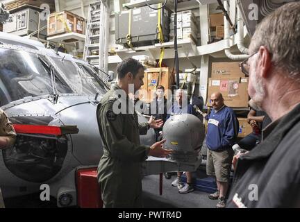 Oceano Pacifico (20 giugno 2017) Lt. La Cmdr. Andrew Poreda, un pilota in carica di elicottero imbarcato Maritime Strike Squadron (HSM) 78, insegna a familiari e amici dei membri dell'equipaggio a bordo Arleigh Burke-class guidato-missile destroyer USS Wayne E. Meyer (DDG 108) circa un MH-60R Sea Hawk elicottero attaccato al HSM-78 durante una tigre cruise tour. Gli Stati Uniti Marina ha pattugliato il Indo-Asia-Pacifico di routine per più di 70 anni regionale di promozione della pace e della sicurezza. ( Foto Stock