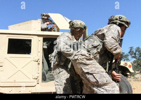 I soldati della 341 Polizia Militare Company, duecentesimo della Polizia Militare il comando assalto avanti durante una simulazione di firefight a Fort Hunter Liggett, California, 19 giugno 2017.Oltre 3000 U.S. La riserva di esercito di soldati sono partecipanti alla 84ma la formazione del comando esercizio guerriero (WAREX) 19-17-03 a Fort Hunter Liggett, California; La WAREX è una larga scala di formazione collettiva piattaforma per generare in grado, letale e lottare contro le forze di pronto. Stati Uniti Esercito Foto Stock