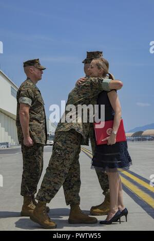 Stati Uniti Marine Corps Il Mag. Gen. Russell A. Sanborn, a sinistra il comandante generale del primo velivolo Marina Wing, III Marine forza expeditionary, abbracci la sig.ra Kimberly Shipley, destra, moglie di ex Marine Aircraft Group (MAG) 12 comandante, dopo una presentazione del premio, durante un cambio del comando cerimonia al Marine Corps Air Station Iwakuni, Giappone, 23 giugno 2017. Dopo due anni di servizio dedicato a MAG-12, U.S. Marine Corps Col. Daniel Shipley è stato sollevato dalle sue funzioni per continuare a servire e a Washington D.C. presso la sede Marine Corps con programmi e risorse. Foto Stock