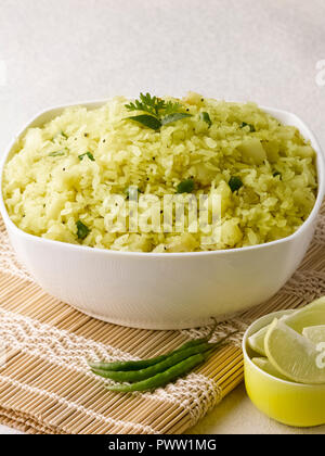 BATATA POHA realizzato da riso soffiato fiocchi di patate e cipolle. servita con calce e peperoncini verdi Foto Stock