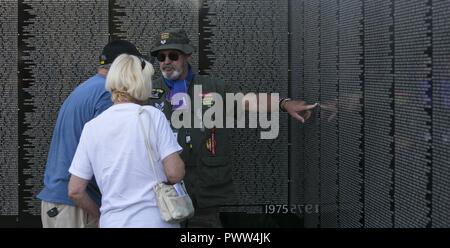 Ritirato Air Force Staff Sgt. Dennis Blessman parla ai visitatori circa la movimentazione veterano del Vietnam Memorial Wall dopo il programma di apertura alla missione Springs Park in Desert Hot Springs, California, 22 giugno 2017 la parete mobile, un modello in scala originale del Vietnam Veterans Memorial Wall, ha i nomi di quegli uomini e quelle donne che erano stati uccisi o scomparsi in azione incise su una pietra riflettente, in modo che i visitatori non solo possono vedere i nomi, ma di vedere se stessi, riflettendo sulla vita di persone che hanno combattuto e sono morti per tenerli al sicuro. Foto Stock