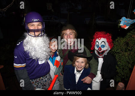 I ragazzi di Halloween costume per il trucco o il trattamento in clown, cowboy e bianco barbuto Santa Claus in Minnesota Viking uniforme. St Paul Minnesota MN USA Foto Stock