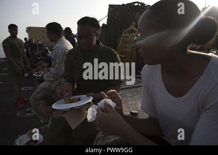 Mare Arabico (Luglio 1, 2017) Marines e marinai divertirsi mentre si celebra a bordo della USS Carter hall (LSD 50), 1 luglio 2017, durante un giorno di indipendenza di acciaio picnic sulla spiaggia. Il ventiquattresimo Marine Expeditionary Unit è attualmente distribuito negli Stati Uniti Quinta Flotta area di operazioni a sostegno della sicurezza marittima operazioni destinate a rassicurare gli alleati e partner e preservare la libertà di navigazione e il libero flusso di commercio nella regione. Foto Stock