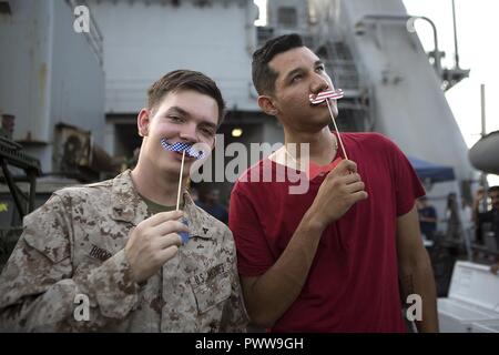 Mare Arabico (Luglio 1, 2017) Marines e marinai divertirsi mentre si celebra a bordo della USS Carter hall (LSD 50), 1 luglio 2017, durante un giorno di indipendenza di acciaio picnic sulla spiaggia. Il ventiquattresimo Marine Expeditionary Unit è attualmente distribuito negli Stati Uniti Quinta Flotta area di operazioni a sostegno della sicurezza marittima operazioni destinate a rassicurare gli alleati e partner e preservare la libertà di navigazione e il libero flusso di commercio nella regione. Foto Stock