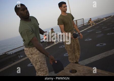 Mare Arabico (Luglio 1, 2017) Marines gioco foro di mais mentre festeggia a bordo della USS Carter hall (LSD 50), 1 luglio 2017, durante un giorno di indipendenza di acciaio picnic sulla spiaggia. Il ventiquattresimo Marine Expeditionary Unit è attualmente distribuito negli Stati Uniti Quinta Flotta area di operazioni a sostegno della sicurezza marittima operazioni destinate a rassicurare gli alleati e partner e preservare la libertà di navigazione e il libero flusso di commercio nella regione. Foto Stock