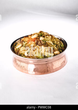 BIRYANI di verdure servita in un rame HANDI. Esso è realizzato con riso e verdure miste cucita con masala e guarnita con noci e uvetta Foto Stock