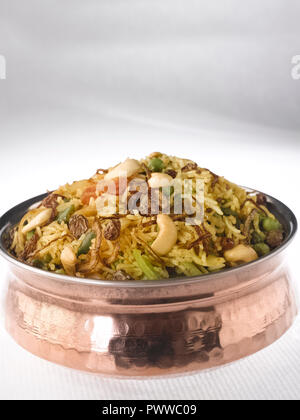 BIRYANI di verdure servita in un rame HANDI. Esso è realizzato con riso e verdure miste cucita con masala e guarnita con noci e uvetta Foto Stock