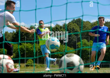 Ramstein Air Base aviatori e Fussballverein Ramstein Fußball Club un team di giocare una partita di calcio durante il programma Grassroots giornata di sport, a Fv Olympia Campo in Ramstein Misenbach, Germania, 24 giugno 2017. Il programma Grassroots ha lo scopo di coinvolgere gli avieri socialmente nella comunità locale, forgia amicizie e aumentare la consapevolezza della cultura tedesca e la comprensione generale. Foto Stock