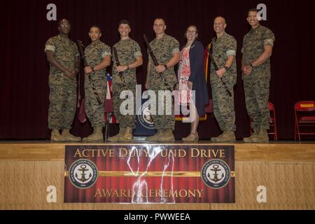 (Da sinistra a destra) U.S. Marine Corps Master Gunnery Sgt. Tarik Inge, 1 Sgt. Michael Collins, 1Lt. Timothy Stewart, Master Sgt. Joshua Hooten, Elizabeth Moore, Col. Henry Lutz e Col. David Jones posa per una foto di gruppo al fine di un 2017 Navy-Marine Corps Relief Society (NMCRS) Active Duty fondo rigido durante una cerimonia di premiazione presso il Camp Foster Community Center di Camp Foster, Okinawa, in Giappone, luglio 6, 2017. Il NMCRS fornito sollievo finanziario al servizio attivo e pensionati Marines e marinai come pure i loro superstiti ammissibili familiari attraverso prestiti senza interessi e le sovvenzioni. Foto Stock